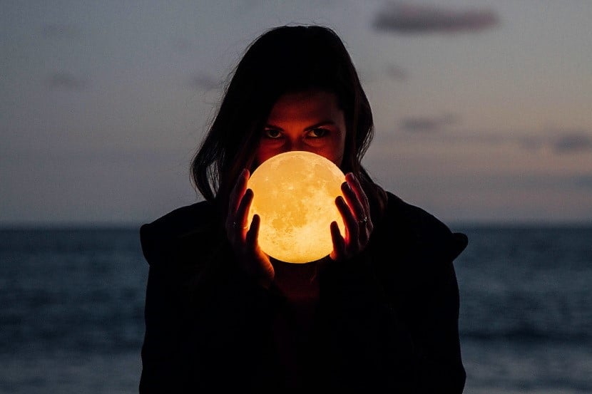 Schwangere in der Abenddämmerung mit Mondlampe in der Hand