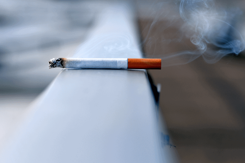 rauchende Zigarette auf Geländer