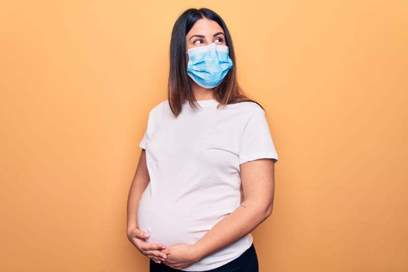 Schwangere mit Maske als Schutz vor Covid-19