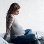 Schwangere Frau mit Tattoos