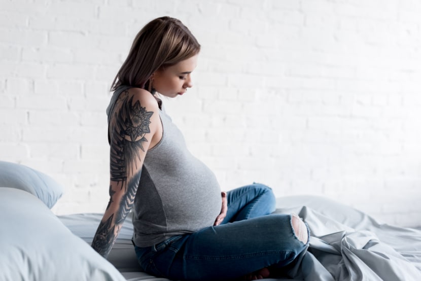 Schwangere Frau mit Tattoos